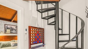 A modern interior with a spiral staircase, a wooden floor, and a wall-mounted board game. - Walk to SKi Slopes  and Hot Tub (Wintergreen Resort)