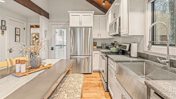 A modern kitchen with white cabinetry, stainless steel appliances, and a large window. - Walk to SKi Slopes  and Hot Tub (Wintergreen Resort)