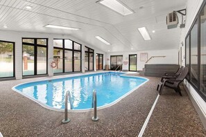 An indoor swimming pool with clear glass walls, a tiled floor, and a few lounge chairs. - Enjoy the Indoor Pool, Hot Tub and Sauna! Free Daily Attraction Tickets (Branson)