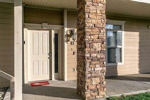A house entrance with a stone pillar, a white door, and a mailbox. - Table Rock Lake - Emerald Pointe - Walk In Condo w Lake and Pool Access- Free Daily Tickets (Hollister)