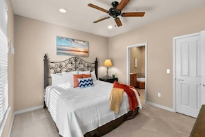 A bedroom with a bed, a ceiling fan, a nightstand with a lamp, and a door. - Table Rock Lake - Emerald Pointe - Walk In Condo w Lake and Pool Access- Free Daily Tickets (Hollister)