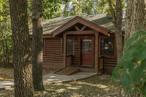 A rustic log cabin with a red door and a number '152' on the front. - Genuine Log Cabin with Fireplace, Whirlpool Tubs, Onsite Amenities, Free Daily Attraction Tickets (Branson)