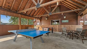 An indoor recreational area with a foosball table, ping pong table, and seating area.
