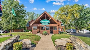 A Marketplace Group Sales building with a clear sky, surrounded by trees and a parking area.