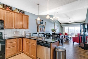 A modern kitchen with wooden cabinets, a stainless steel dishwasher, and a large island. - Majestic Condo on Table Rock Lake - Views for Mile- Free Daily Attraction Tickets (Branson)