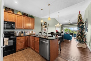 A modern kitchen with wooden cabinets, stainless steel appliances, and a large island. - Majestic Condo on Table Rock Lake - Views for Mile- Free Daily Attraction Tickets (Branson)