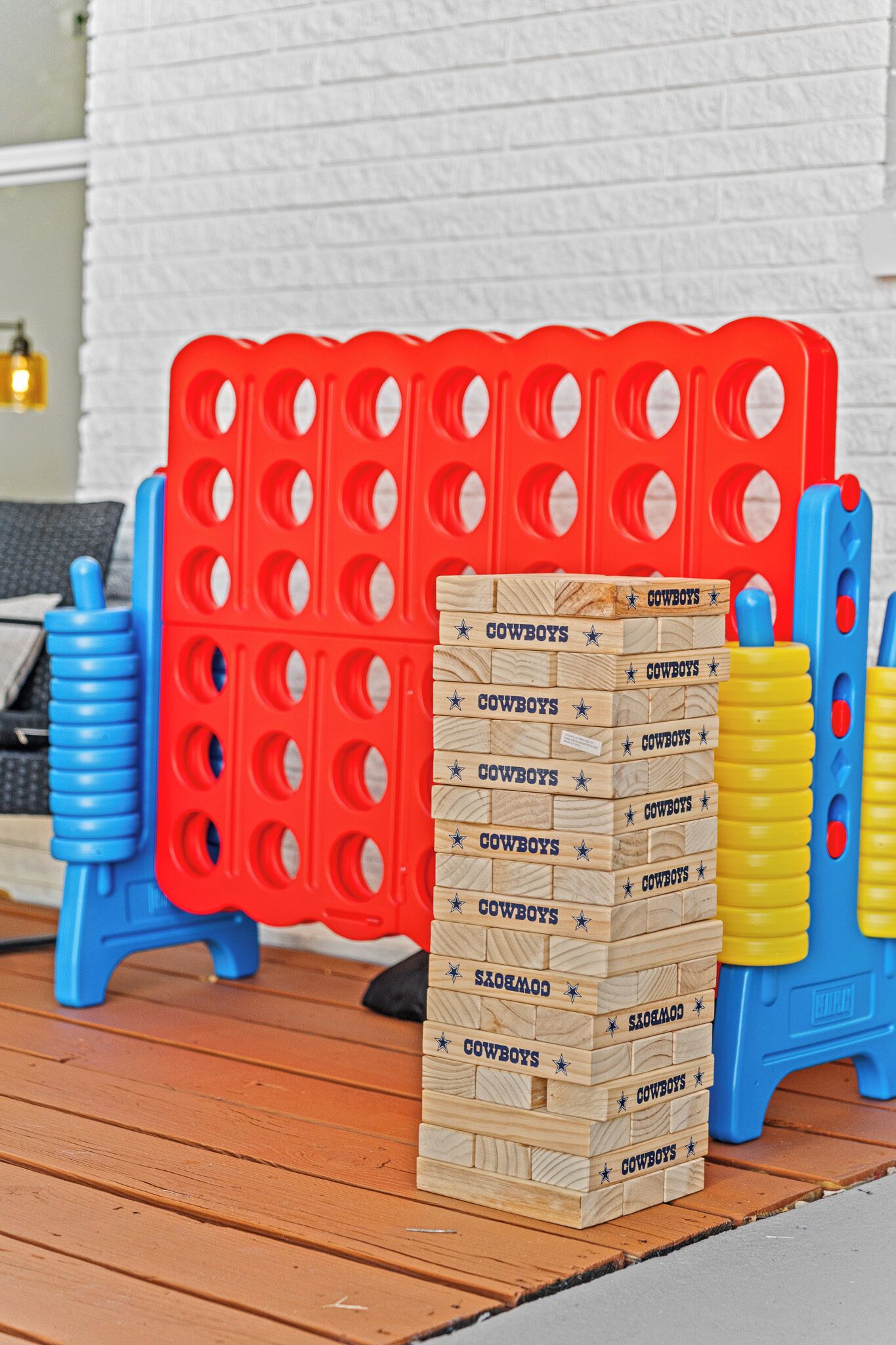 A stack of wooden blocks with 'COWBOYS' written on them, placed on a wooden deck.