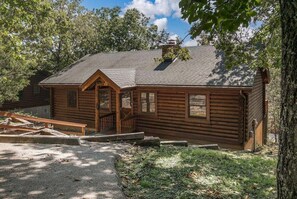 Ein rustikales Holzhaus mit Schornstein, einer Veranda und einem kleinen Fenster.
