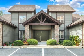 A two-story building with a central entrance, a garage door, and a brick facade. - StoneBridge Villa-Near Silver Dollar City-Golf Course Views- Free Daily Attraction Tickets (Branson West)