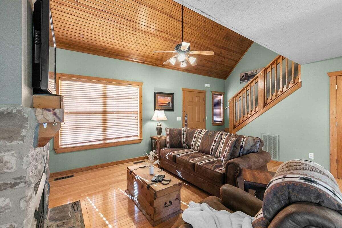 A living room with a wooden ceiling, a sofa, a coffee table, and a fireplace.