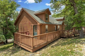A log cabin with a balcony and a staircase leading to the main entrance. - King Bedrooms, Resort Amenities, Free Daily Attraction Tickets (Branson)