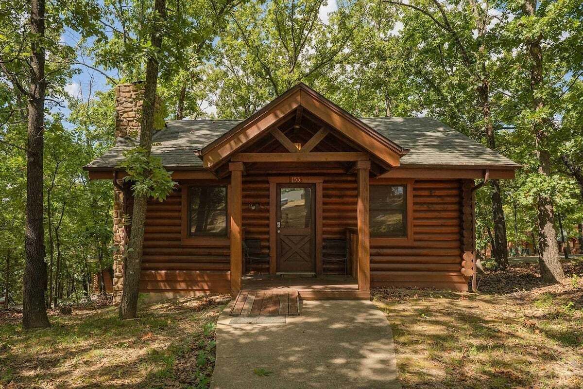 A log cabin with a chimney, a front door, and a number '153' on the door.