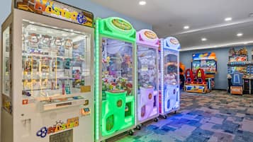 A row of claw machines with colorful designs, labeled with various game titles.