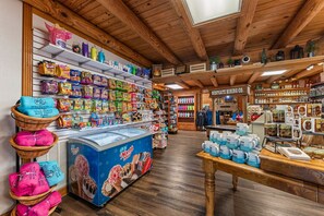 A store with shelves stocked with snacks, a display of ice cream tubs, and a sign for Westgate Mining Co.