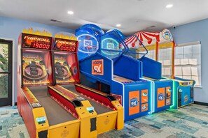 Een speelruimte met gokautomaten, waaronder een basketbalveld en een basketbalspel.