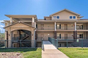 A multi-story building with a central staircase, balconies, and a gated entrance. - Great Condo Just 5 Minutes to Branson!- Free Daily Attraction tickets (Branson)