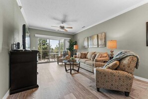 A living room with a sofa, armchair, coffee table, and a television on a stand. - Great Condo Just 5 Minutes to Branson!- Free Daily Attraction tickets (Branson)