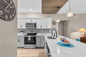 A modern kitchen with white cabinets, a microwave, an oven, and a sink. - Free Daily Attraction Tickets, Big Patio, King Beds, Close to Everything (Branson)