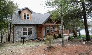 A two-story cabin with a stone facade, wooden deck, and a stone mailbox. - Private Lodges, Resort Property, Fireplaces, Free Daily Attraction Tickets (Branson West)