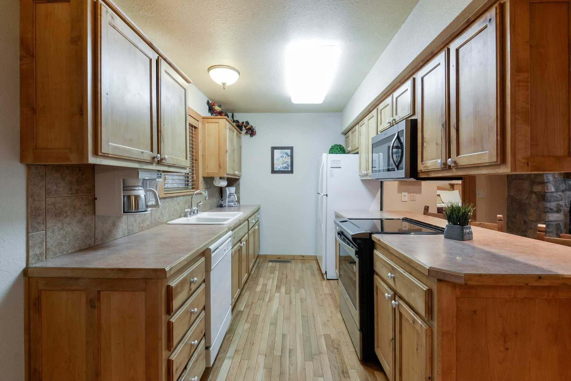 A compact kitchen with wooden cabinets, a microwave, and a refrigerator.
