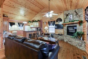 Ein gemütliches Blockhauss-Interieur mit Wohnbereich, Küche und Kamin.