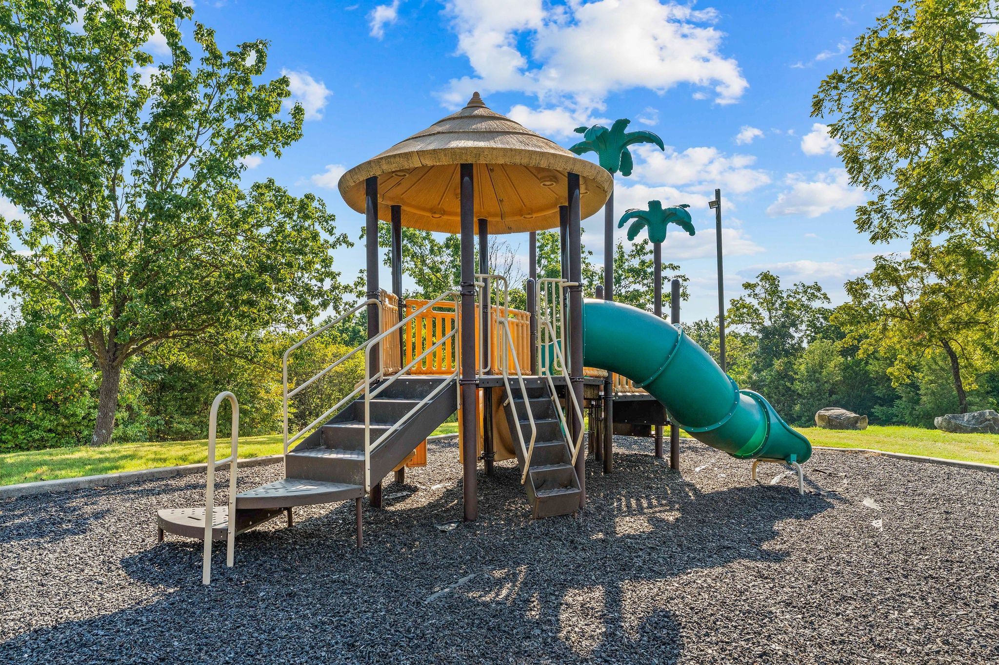 A playground with a slide, a climbing structure, and a covered play area.