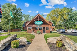 A Marketplace Group Sales building with a clear sky, surrounded by trees and a parking area. - Beautiful Wooded Views, Near SDC, Whirlpool Tubs, Free Daily Attraction Tickets (Branson)