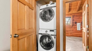 A laundry room with two stacked front-loading washing machines. - Private Cabin with Whirlpool Tubs, Free Wifi, 150 Beautiful Acres (Branson)