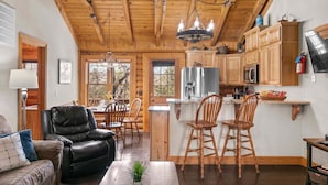 A cabin interior with a dining area, kitchen, and living space. - Private Cabin with Whirlpool Tubs, Free Wifi, 150 Beautiful Acres (Branson)