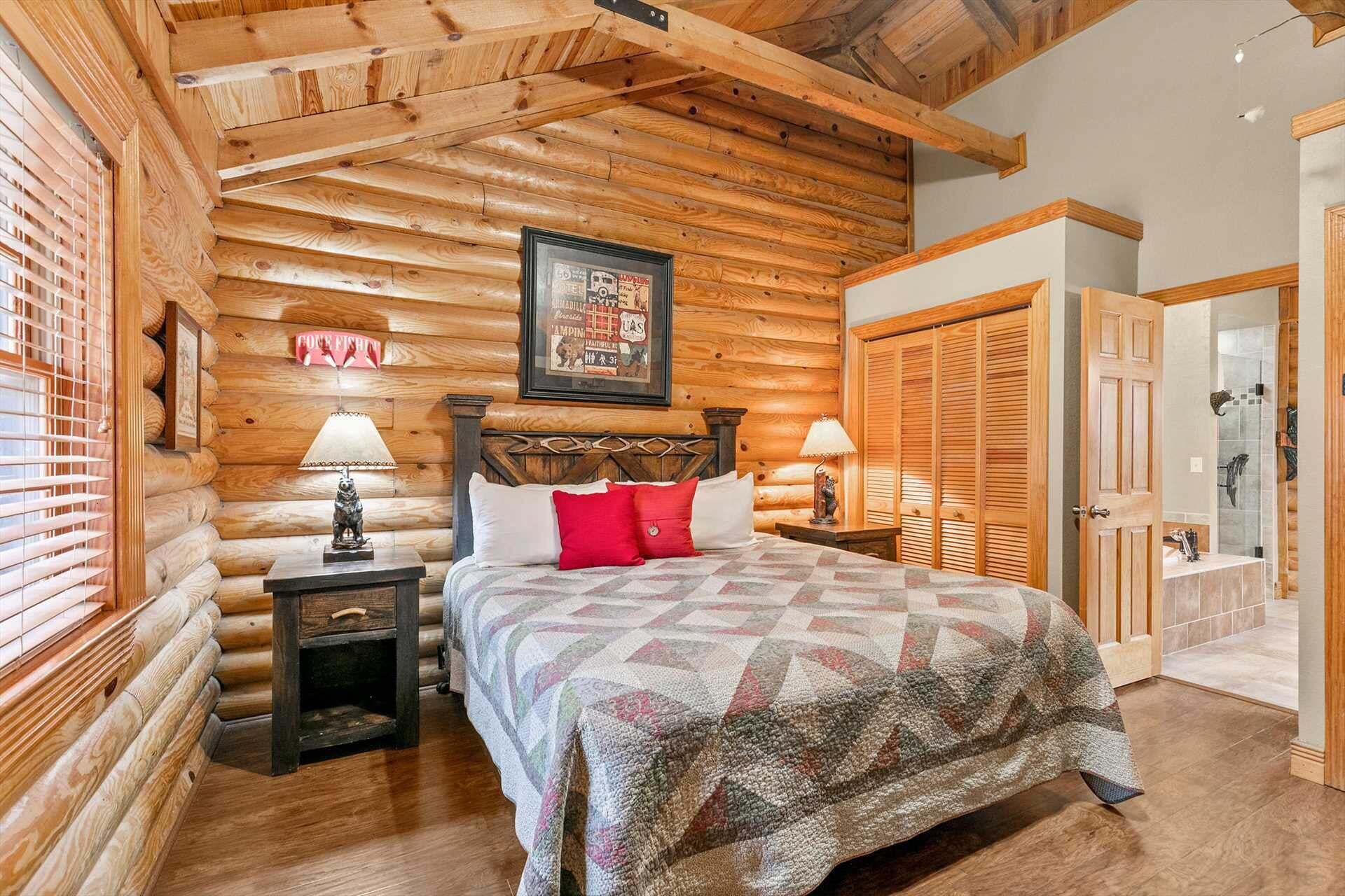 Un dormitorio tipo cabaña de madera con una cama, dos mesitas de noche, un cartel enmarcado y paredes de madera.