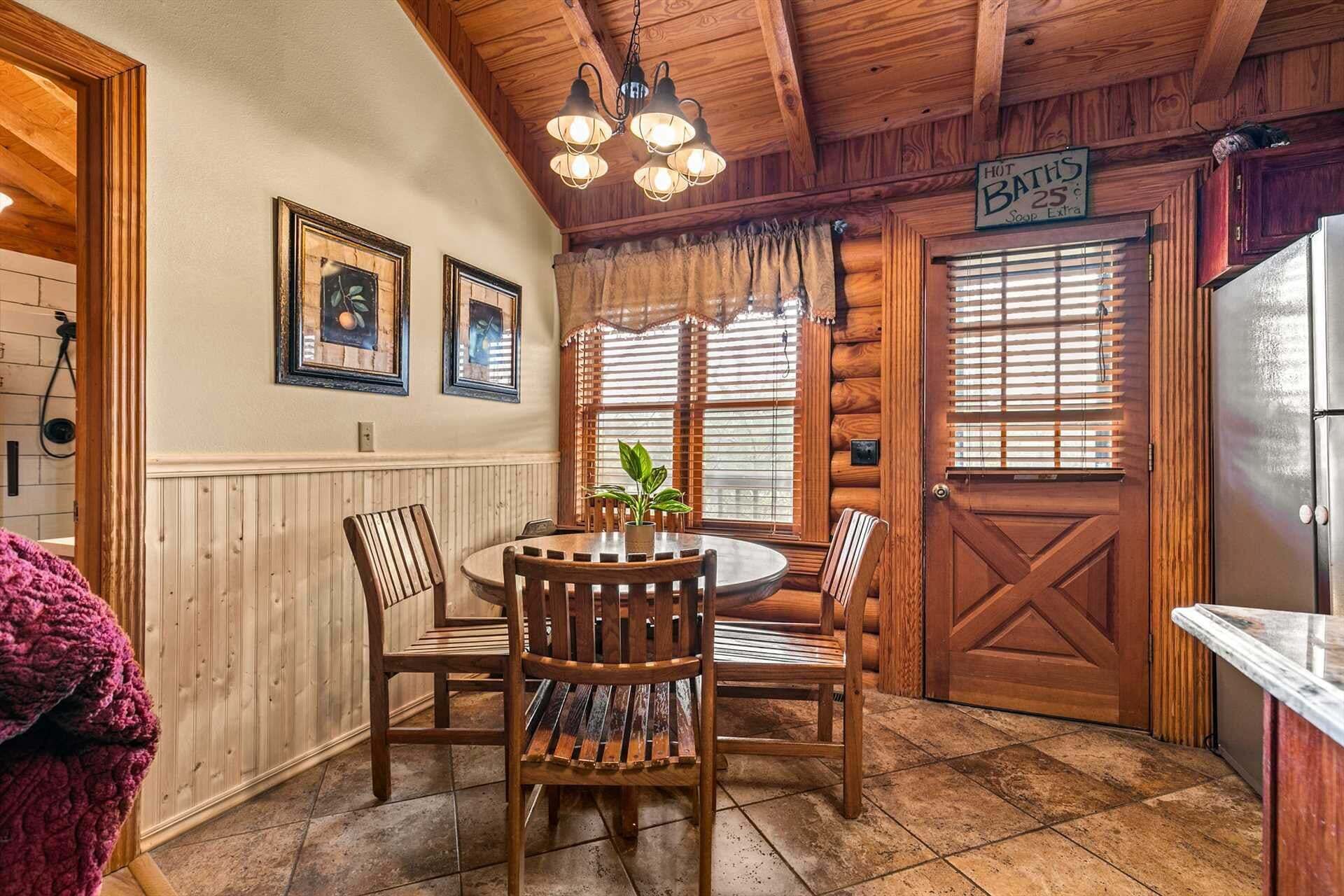 A wooden interior with a round table, chairs, a refrigerator, and a sign indicating a hot bath price.