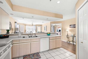 A modern kitchen with a central island, a built-in dishwasher, and a view into the dining area. - Cozy Condo_ Free Daily Attraction Tickets_ Close to Branson (Branson)