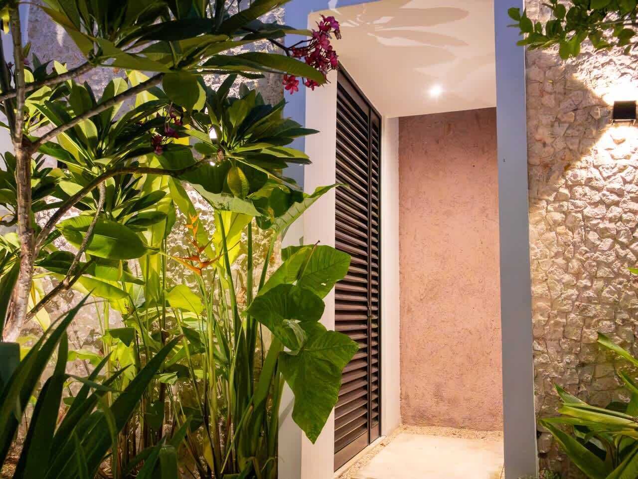 A modern building with a stone wall and a door with horizontal slats.