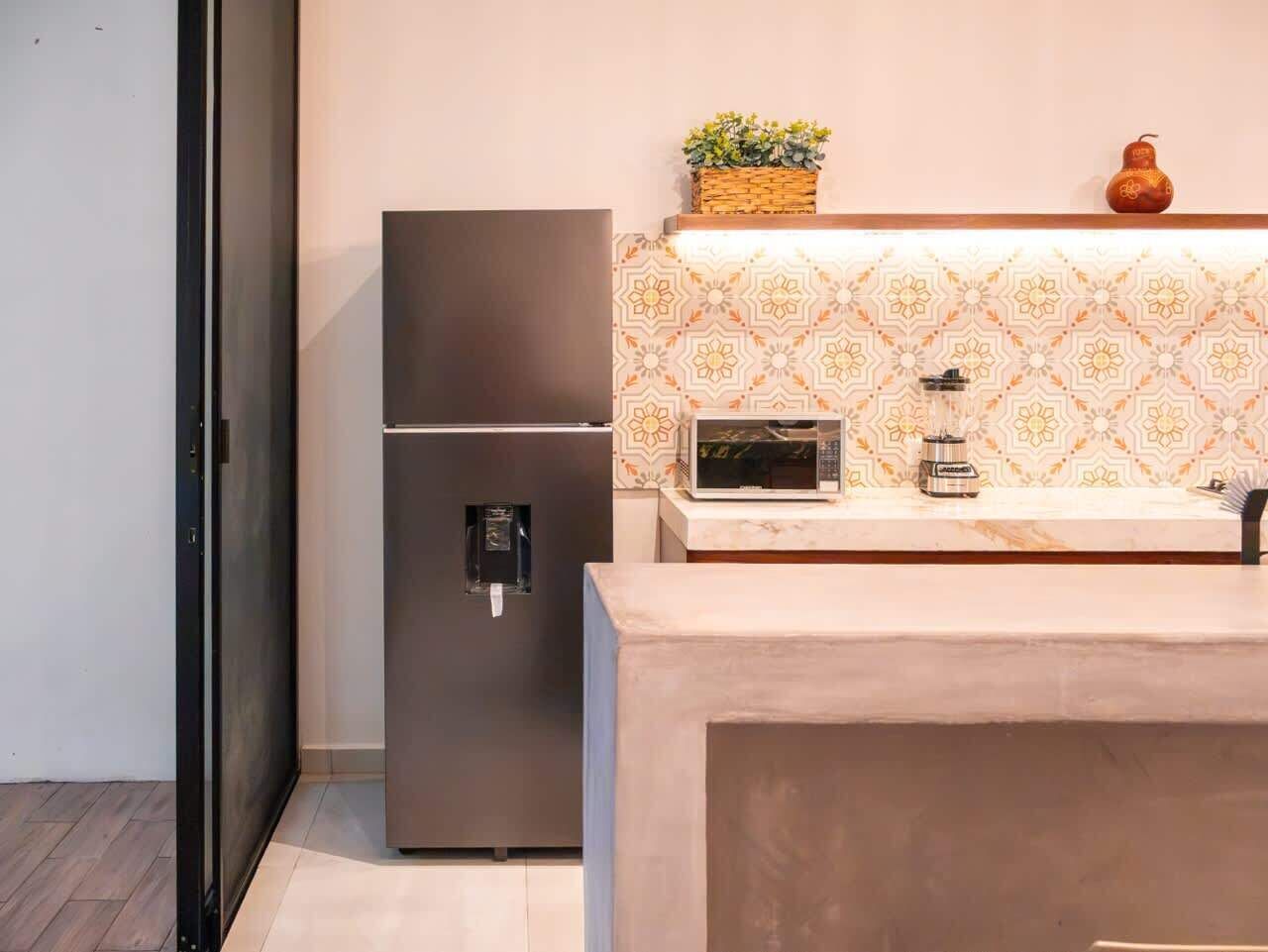 A compact kitchen with a refrigerator, microwave, and a small sink.