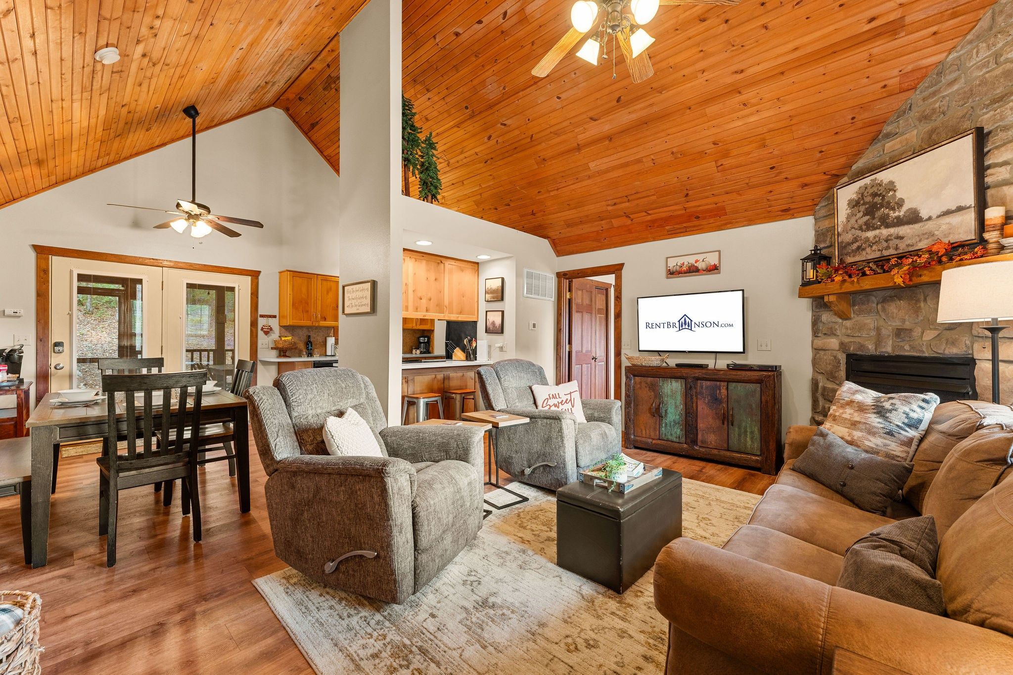 A spacious living room with a fireplace, a television, and a dining area with a wooden table and chairs.