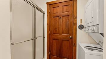 A laundry room with a wooden door, a washing machine, and a dryer.