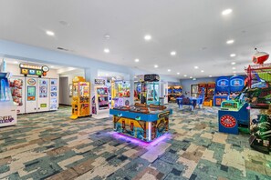A brightly lit arcade area with various gaming machines and a prize hub. - Real Log Cabin, Beautiful Screened in Porch, Fireplace, Free Attraction Tickets (Branson)