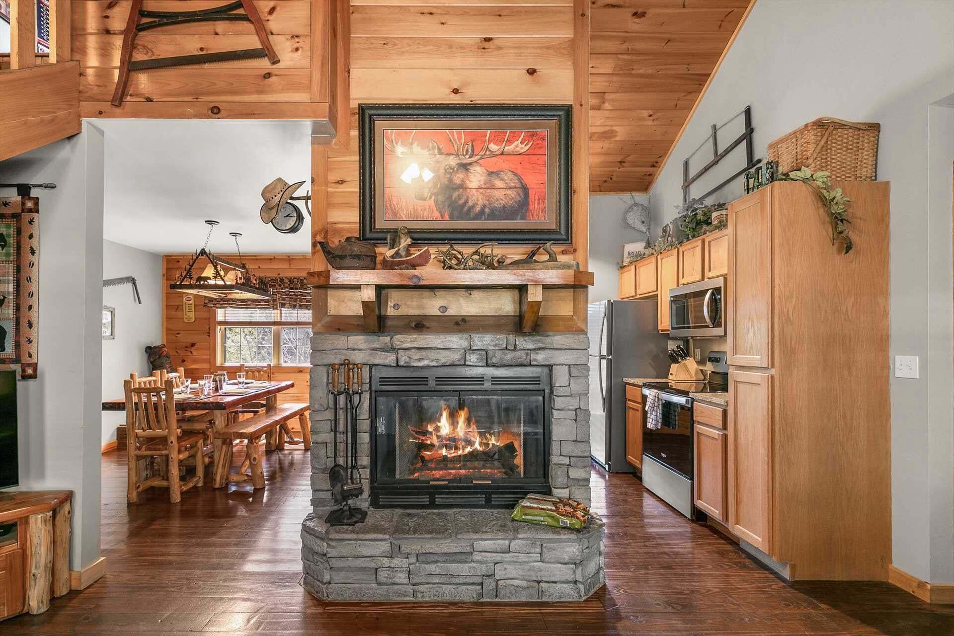 Ein rustikales Interieur mit Kamin aus Stein, einer Essgelegenheit aus Holz und einer Küche mit Holzausstattung.