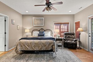 A bedroom with a bed, a chair, a ceiling fan, a window with blinds, and a door. - Beautiful Golf Course view, Near SDC, Lots of Space, Free Daily Attraction Tickets (Branson West)