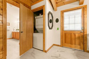 A wooden interior with a door leading to a laundry area, a mirror, and a window with blinds. - Free Daily Attraction Tickets, Four King Rooms, Huge Sunroom, Shared Arcades (Branson)