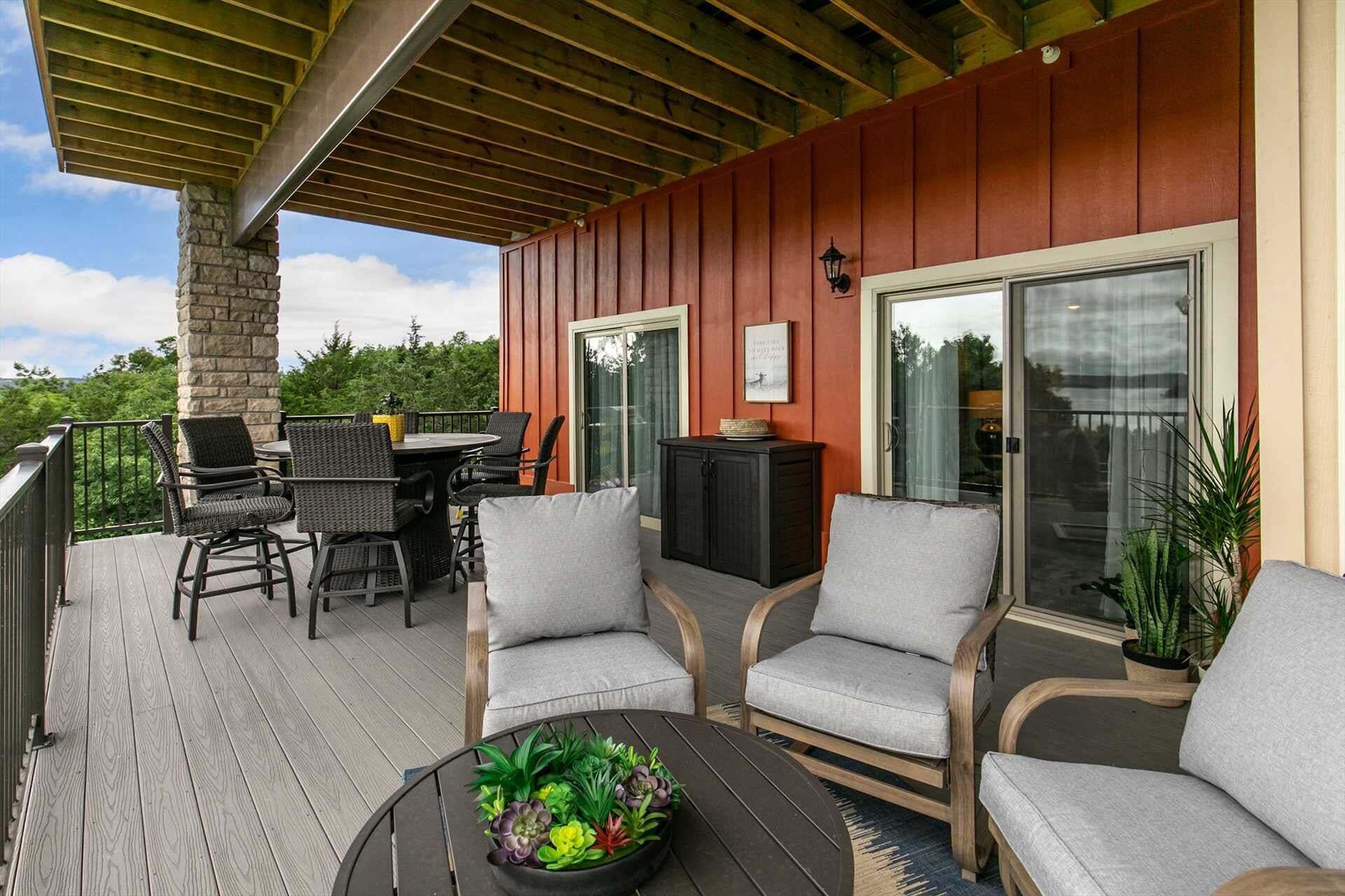 An outdoor deck with wicker furniture, a table with a plant centerpiece, and a sliding glass door.