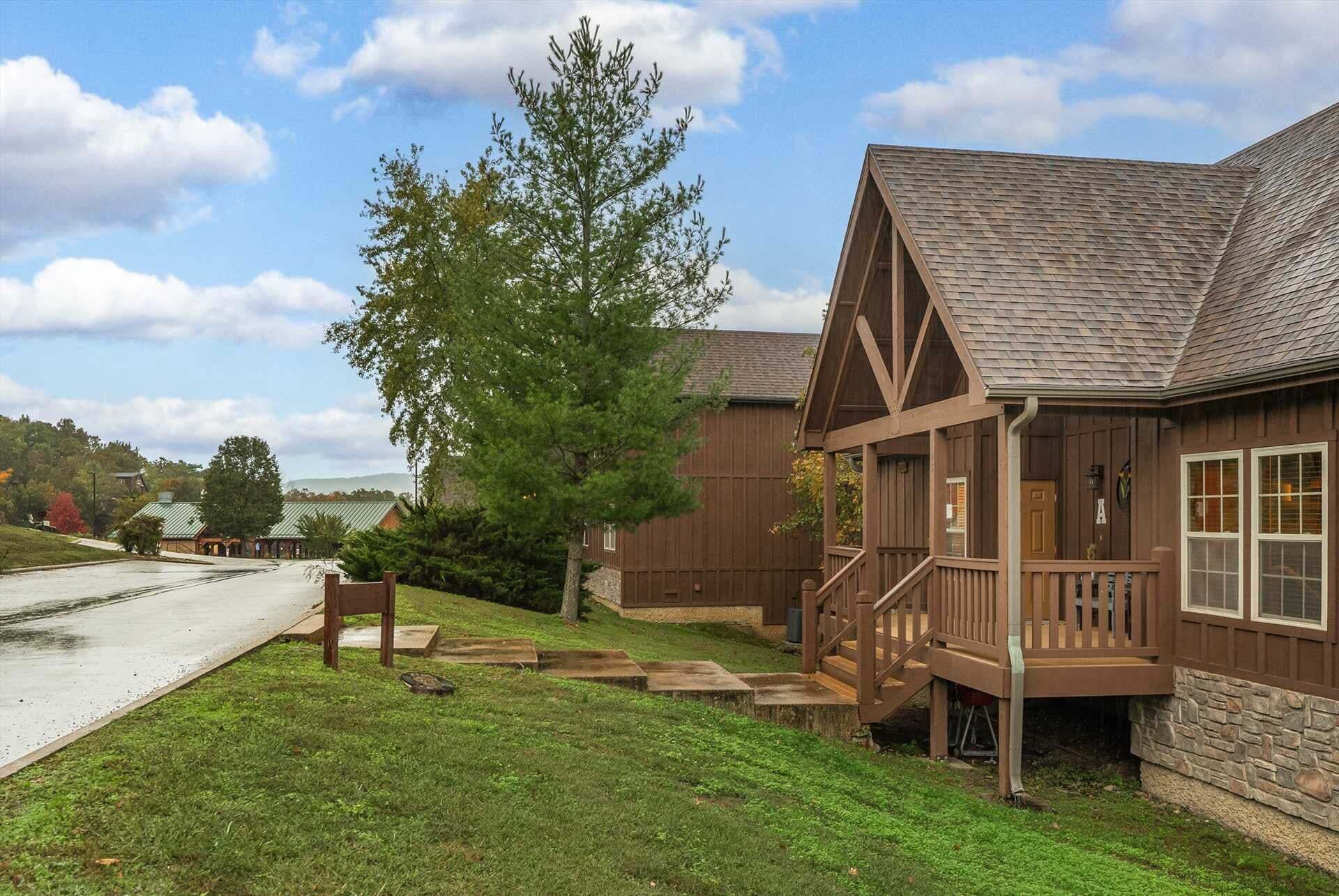 A wooden cabin with a porch and a stone foundation.