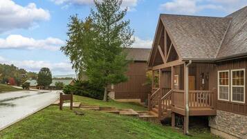 A wooden cabin with a porch and a stone foundation.