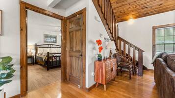 A wooden staircase leading to a bedroom with a bed and a nightstand.