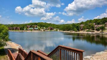 A lakeside view with wooden walkways leading to a building complex.
