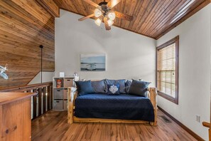 A room with a wooden ceiling, a ceiling fan, a sofa with patterned cushions, a painting on the wall, and a window with blinds. - Stonebridge Lodge, Water Views, Gated Community, Free Daily Attraction Tickets (Branson West)