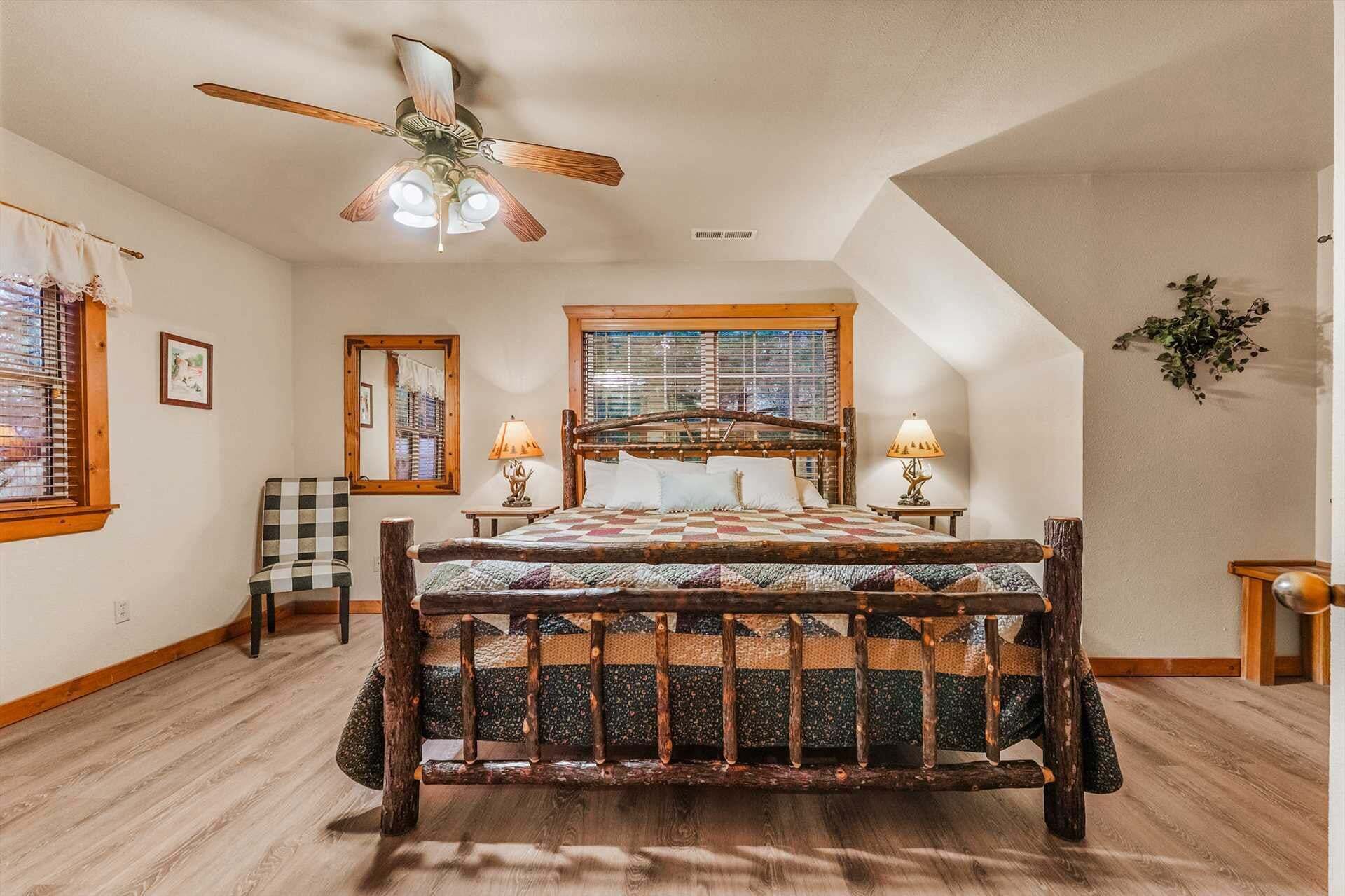 A bedroom with a wooden bed, a ceiling fan, a window with blinds, a lamp, and a plant.