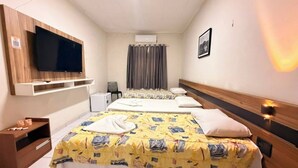 A hotel room with two beds, a TV mounted on the wall, a desk with a chair, and a window with curtains. - Pousada Oásis do Cariri (Juazeiro do Norte)