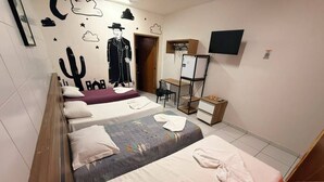 A hotel room with four beds, a desk, a chair, a TV, and a wardrobe. - Pousada Oásis do Cariri (Juazeiro do Norte)