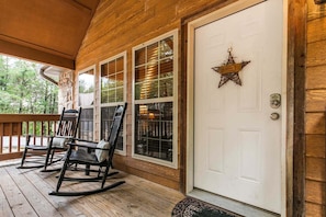 A wooden porch with rocking chairs and a white door with a star decoration. - Near SDC, Private Lake and Fishing, Free Daily Attraction Tickets (Branson West)